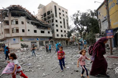 Los residentes se alejan en busca de lugares más seguros entre edificios destruidos y escombros alrededor de la Compañía Palestina de Telecomunicaciones, que fue atacada después de los ataques aéreos israelíes en la Franja de Gaza el 10 de octubre de 2023. Foto: Agencia Anadolu