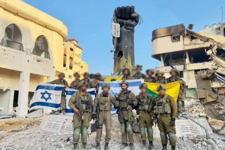 Israeli soldiers pose in front of the destroyed Shejaiya neighborhood in Gaza (Photo via Israeli Defense Forces)