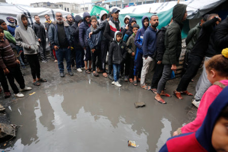 Palestinian refugees in line for food in the rain outside the shelter in Deir al-Balah (Photo: UNRWA)