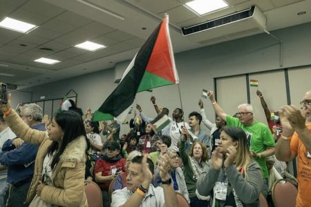 Health workers and activists with the People's Health Movement raise the Palestinian flag at the 5th People's Health Assembly in Mar del Plata, Argentina. Photo: PHM