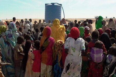 Internally displaced persons with water tank in West Darfur. Photo: Wikimedia commons