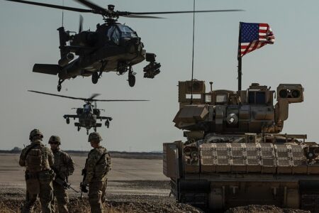US soldiers with an armored vehicle and Apache helicopters. Photo: US Army/ Wikimedia Commons