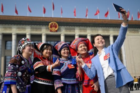 Deputies from the National People’s Congress of China take a photo in front of the Great People’s Hall.
