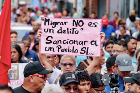 "Migration is not a crime, sanctioning a people is" reads a sign at a march on March 25, in Caracas. Photo via VP Venezuela