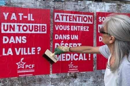An activist from the French Communist Party - Dordogne puts up signs reading: "Is there a doctor in this city?" and "Danger! You are entering a medical desert." Source: PCF Dordogne/X