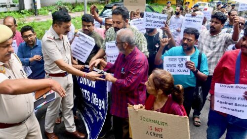 Journalists and activists holding signs argue with police in India