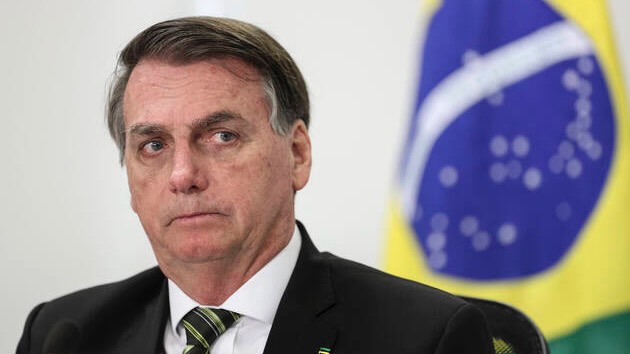 Jair Bolsonaro in front of Brazil flag