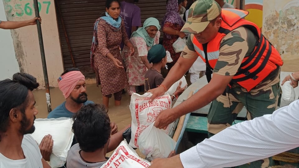 Des travailleurs humanitaires donnent de la nourriture aux victimes des inondations