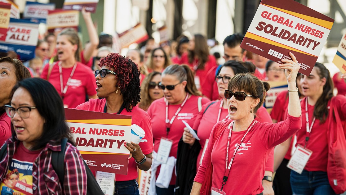 Nurses protest with signs that read: Global Nurses Solidarity