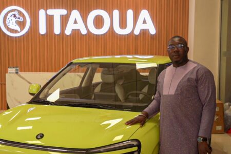 THe 100% electric cars produced in BUrkina Faso Man poses with 100% electric car made in Burkina Faso