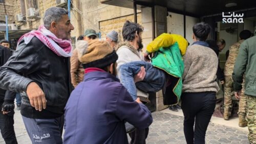 An injured man is carried off by several people in Syria's Aleppo