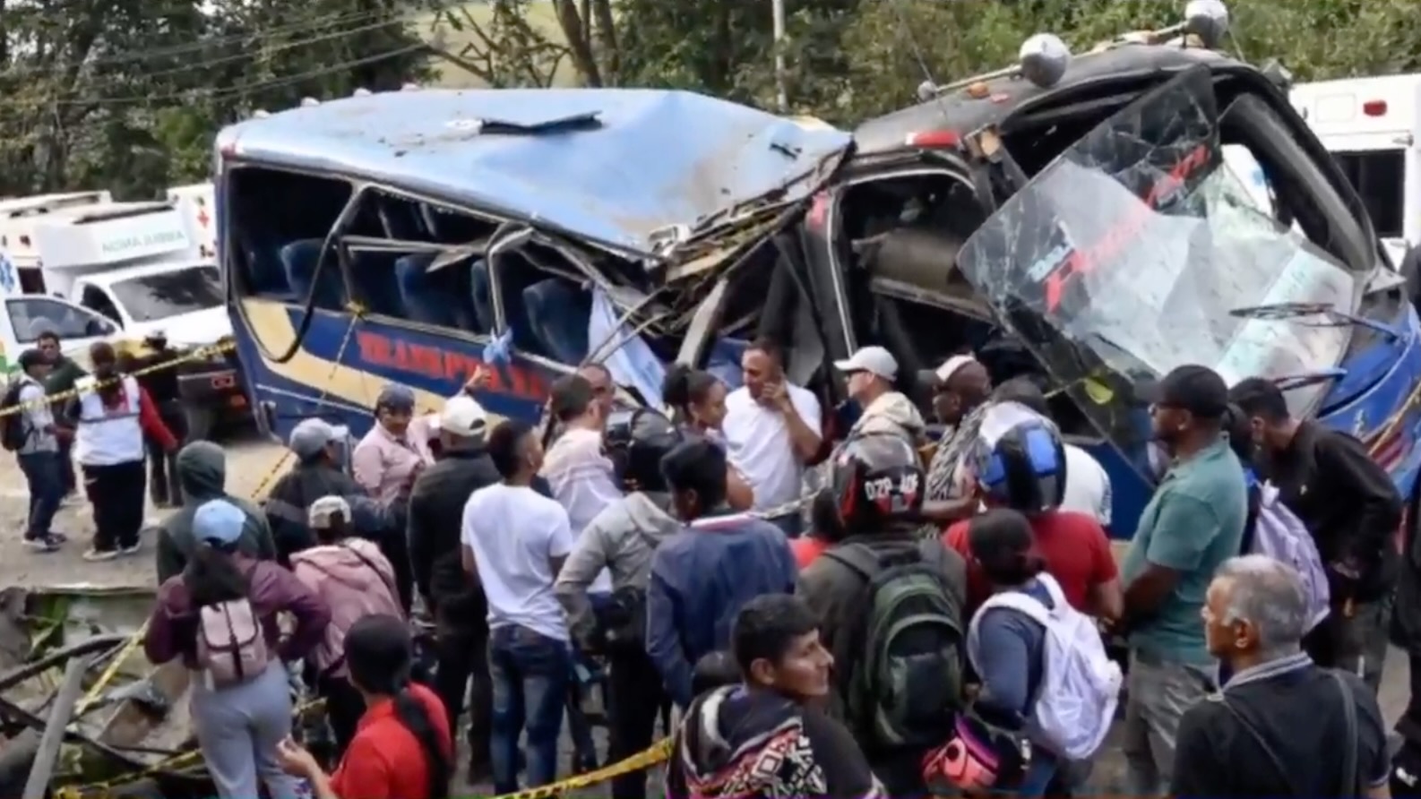 People gather next to an exploded bus on the Pan-American Highway in Colombia